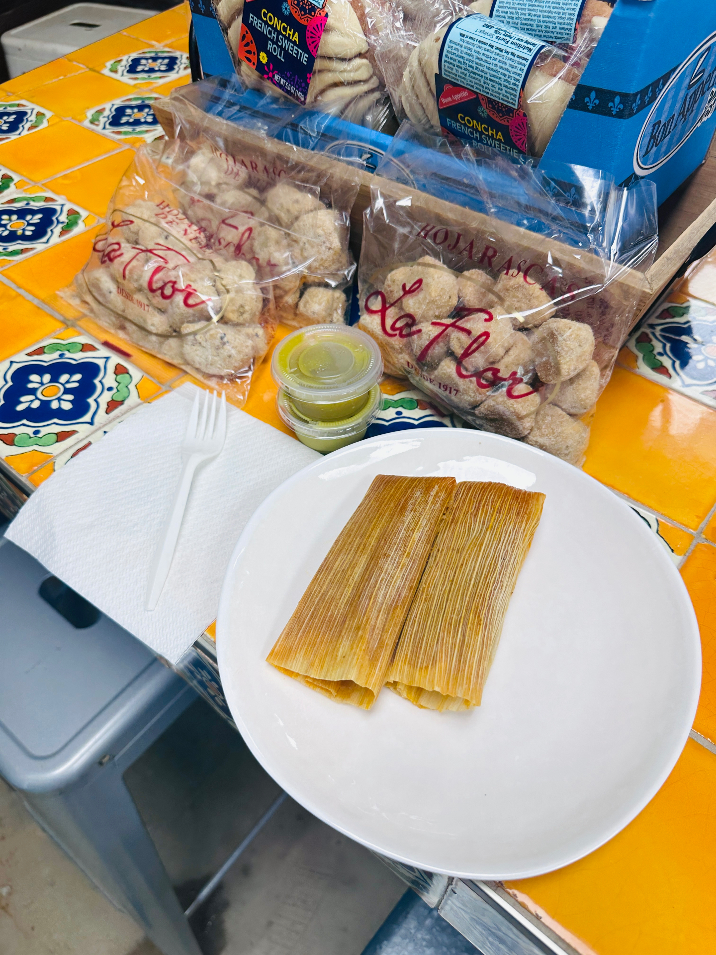 Stack of pork tamales on a plate with red salsa